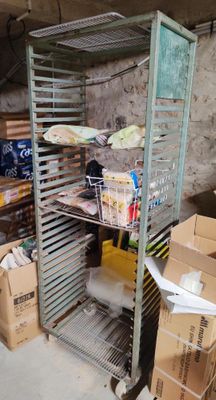 une étagère métallique sur laquelle sont posées des boîtes, dans une pièce