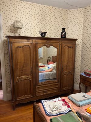 a bedroom with a bed, dresser, mirror and a dresser