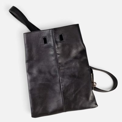 a black leather handbag with two compartments and a strap