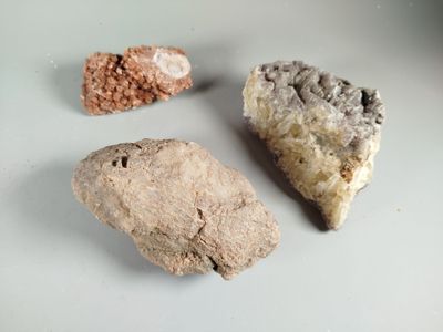 three pieces of rock on a white surface