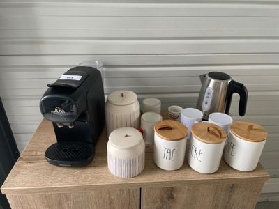 une cafetière et des tasses posées sur une table en bois