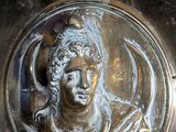 a silver bowl with a statue of a woman on it