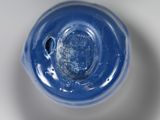 underside view of a blue glass bottle with a hole in it