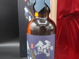 une bouteille de whisky dans un coffret en bois orné d'un ruban bleu