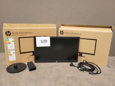 un écran HP posé sur une table à côté d'un carton