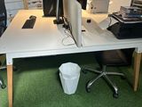 a desk with two computers and a printer on it