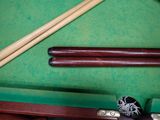 a pool table with two cues and a ball on it