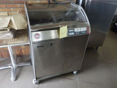une machine posée par terre devant un mur de briques