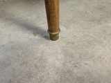 a wooden table with a glass top on a cement floor