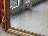 a mirror that is sitting on the floor in front of a door