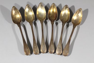 six cuillères sont alignées sur une table