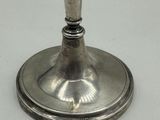 a silver candle holder on a white table