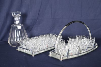 des bouteilles et des verres disposés sur un plateau en argent, avec une carafe en verre sur fond bleu