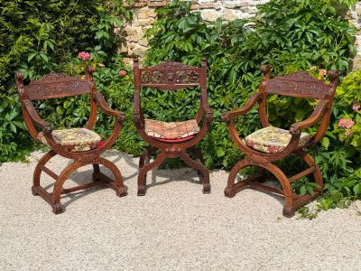 three chairs sitting next to each other in a garden