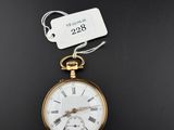 un gros plan d'une montre de poche en or sur laquelle est accrochée une étiquette