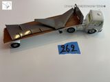 un camion miniature avec un morceau de bois à l'arrière