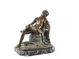 statue en bronze représentant un homme assis sur un rocher avec un chien