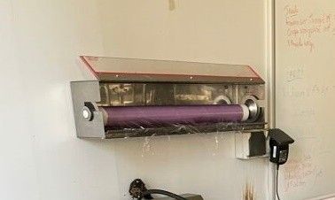 a toilet with a roll of toilet paper on the wall