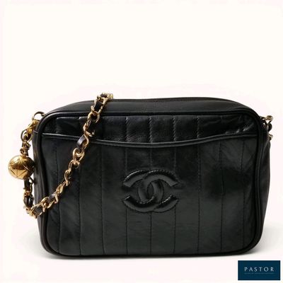 a black chanel bag with a chain around the strap