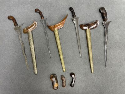 Plusieurs types de couteaux sont exposés sur une surface grise