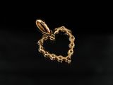 a close up of a gold heart shaped pendant on a black background