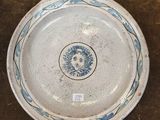 une assiette bleue et blanche posée sur une surface marron