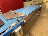 une photo d'un tapis roulant dans un entrepôt, sur lequel se trouve un ordinateur portable