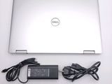 a dell laptop computer with a charger and a power cord