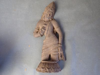 une statue représentant une femme tenant un panier posé sur une table