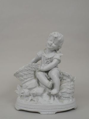 une statue blanche représentant un enfant assis sur un panier