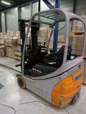 a fork lift truck parked in a warehouse with boxes on the floor