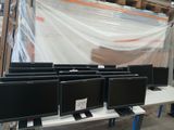 de nombreux écrans d'ordinateur posés sur une table dans un entrepôt