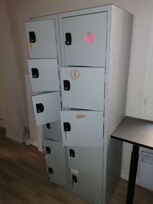 several lockers in the corner of a room with a desk