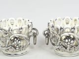 une paire de vases en argent ornés de fleurs sur un fond blanc