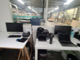 a desk with two computers and a printer on it