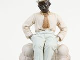 two figurines of a man and a woman sitting on a couch