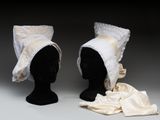 deux têtes de mannequin coiffées de chapeaux, exposées sur une surface grise