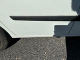 une voiture blanche avec une bande noire, garée sur un parking