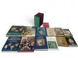 several books are stacked on top of each other on a white surface