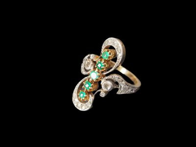 un gros plan d'une bague ornée de pierres vertes et blanches