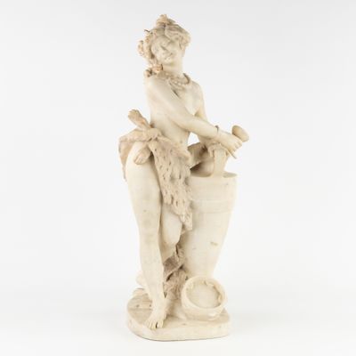 une statue blanche représentant une femme assise sur un vase