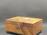 une vieille boîte en bois posée sur une surface grise