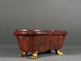 an image of a red and gold bath tub on a gray surface