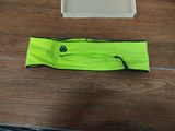 yellow headband with black trim and logo on it sitting on a wooden floor