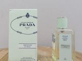 a bottle of prada on a table next to a box of perfume