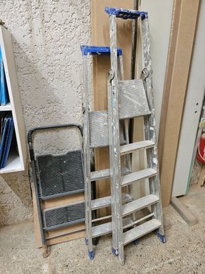 une échelle appuyée contre un mur, à côté d'une pile de livres