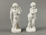 paire de statues blanches représentant des chérubins tenant un Cupidon
