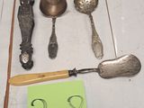 de nombreuses cuillères et couteaux-cuillères en argent posés sur une table