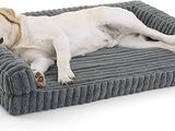 Le chien est allongé sur son panier, posé par terre.