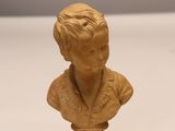 une image représentant une petite statue d'un garçon posée sur une surface blanche